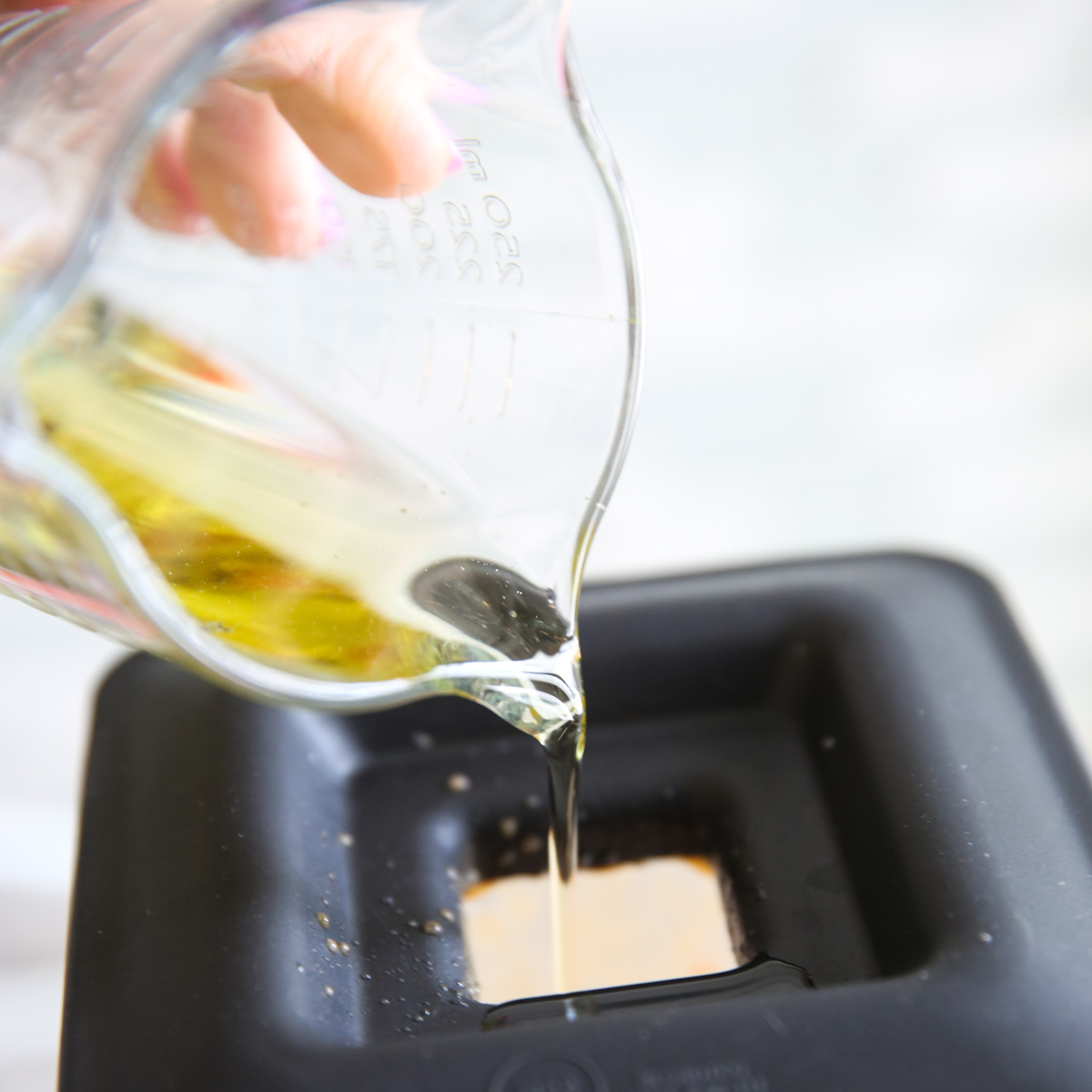 pouring oil into a blender