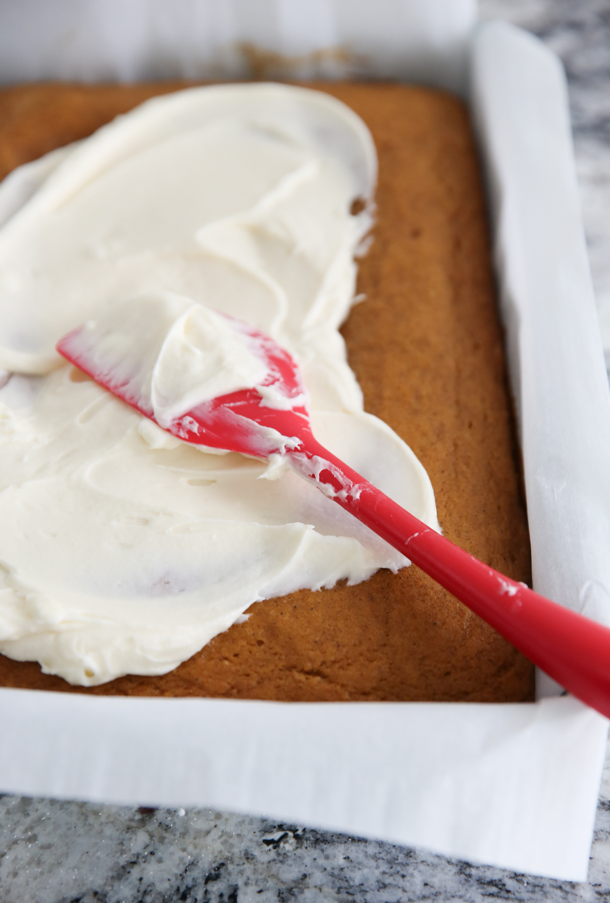 spreading frosting on cake