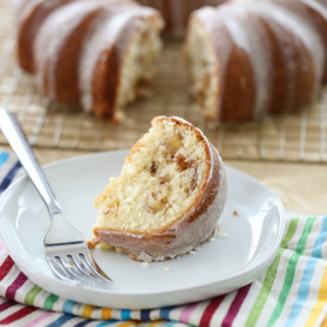 A slice of apple spice bundt cake on a white plate.