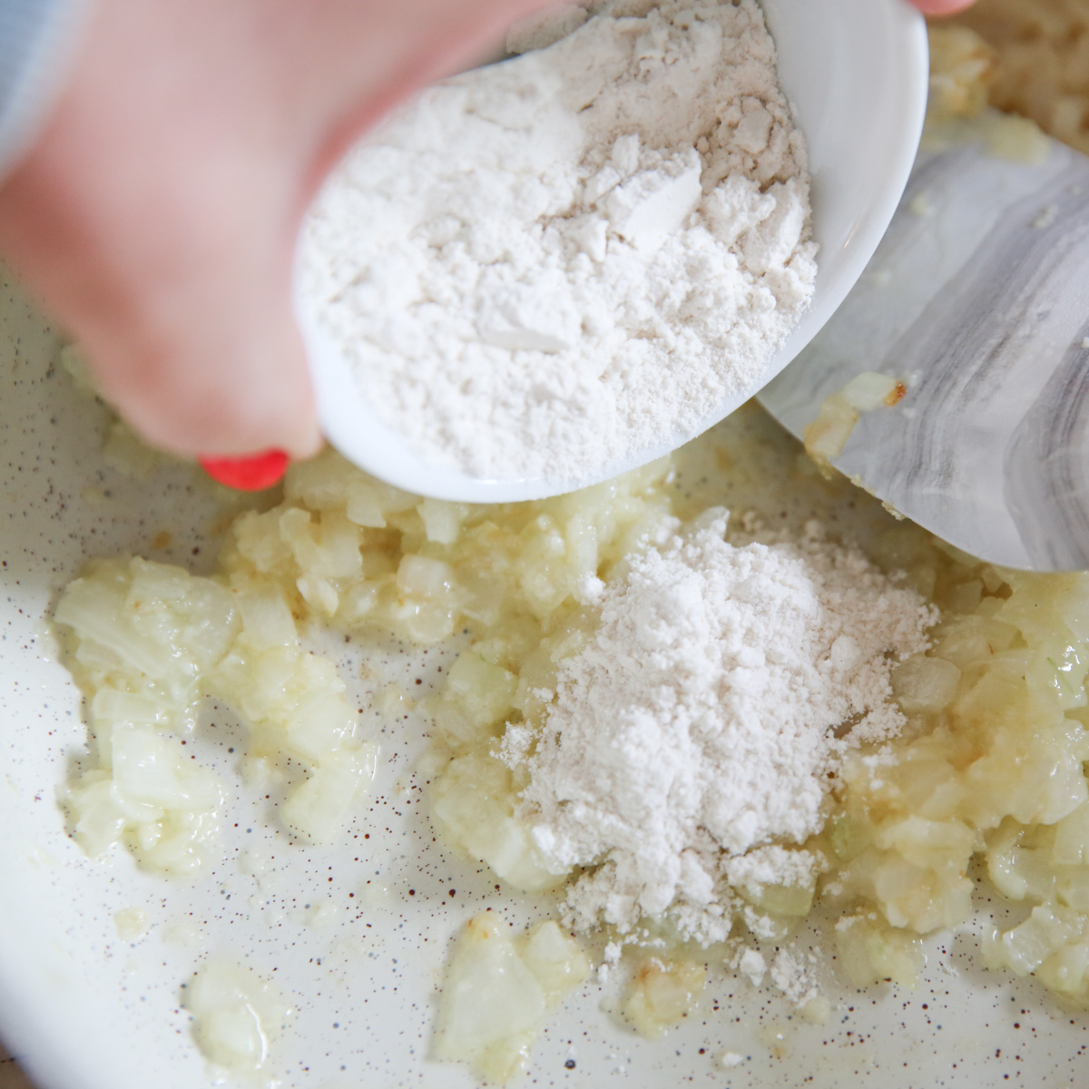 adding flour to a suate pan for a roux