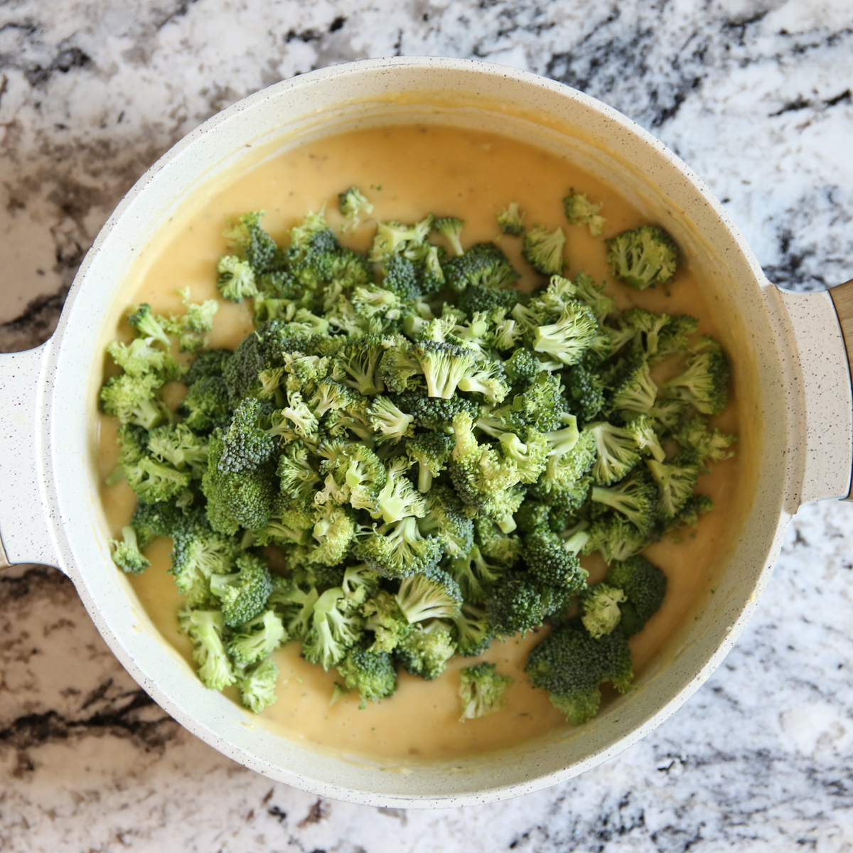 adding broccoli to cheese sauce