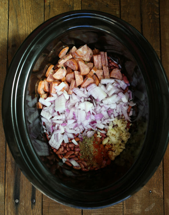 Red Beans and Rice by Our Best Bites - Slow Cooker Dinner - sausage, red onion, beans, and seasonings in a slow cooker