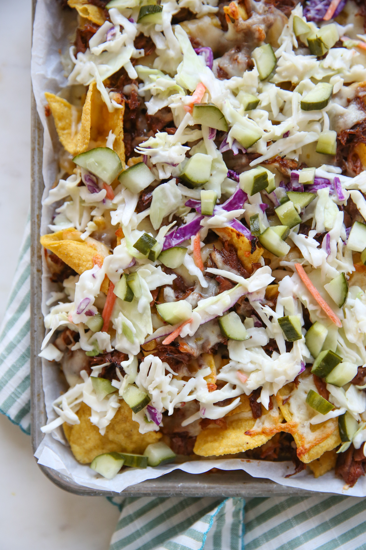 close up of tortilla chips on a sheet pan with cheese and pork