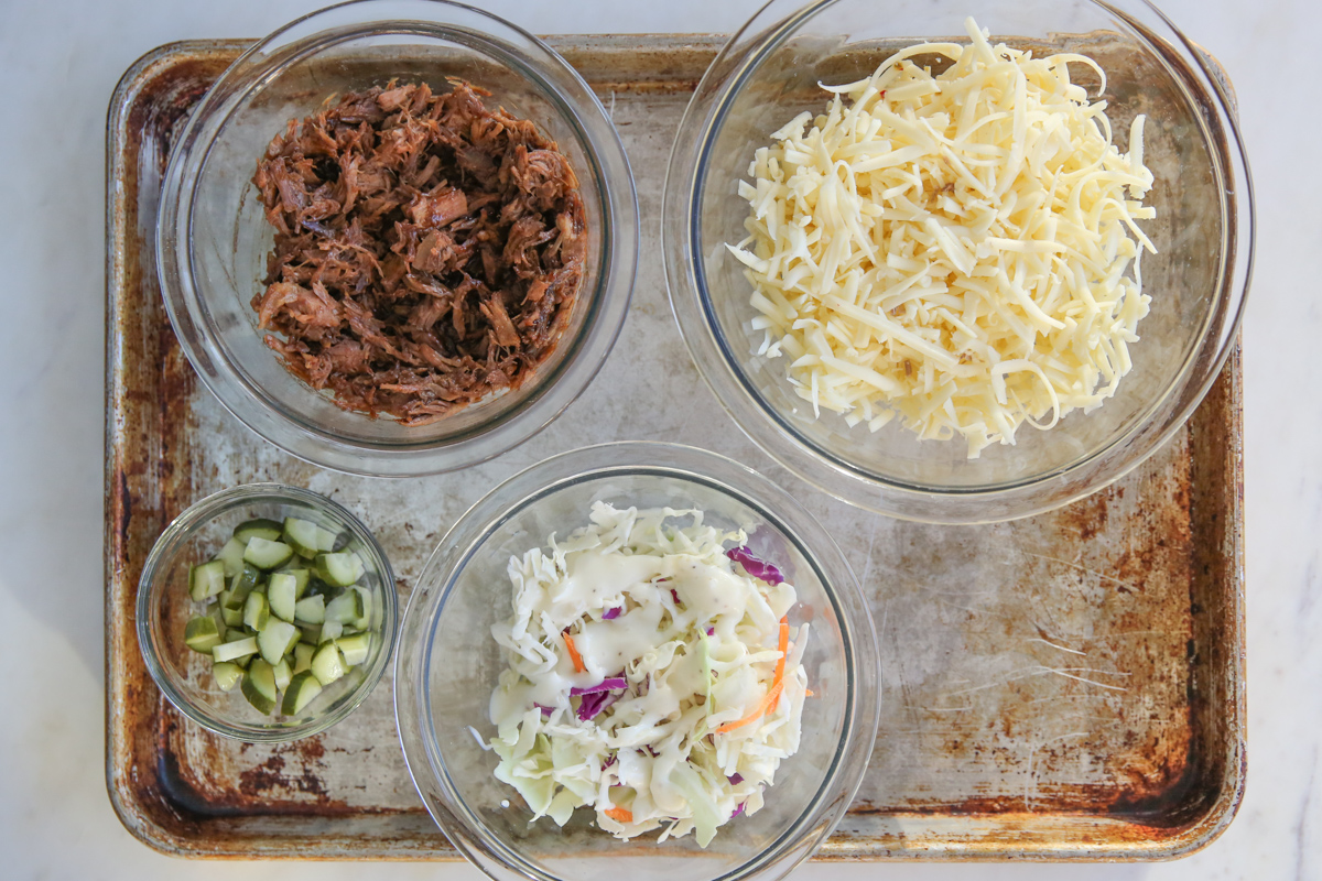 ingredients for pulled pork nachos on a sheet pan