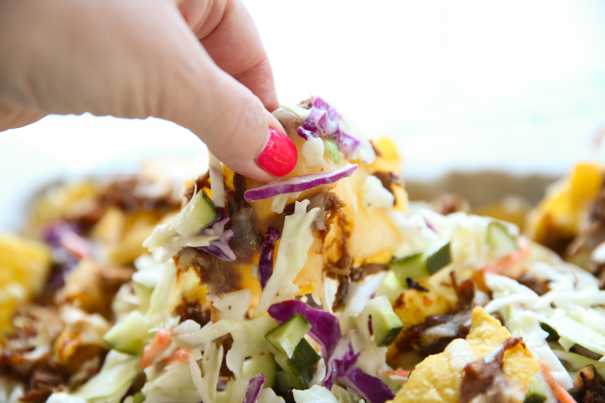 close up of tortilla chips on a sheet pan with cheese and pork