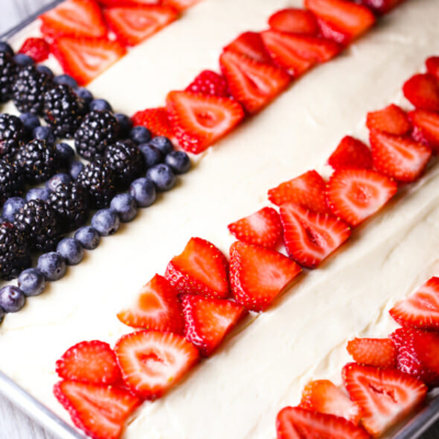 White sheet cake decorated with fruit as an American Flag