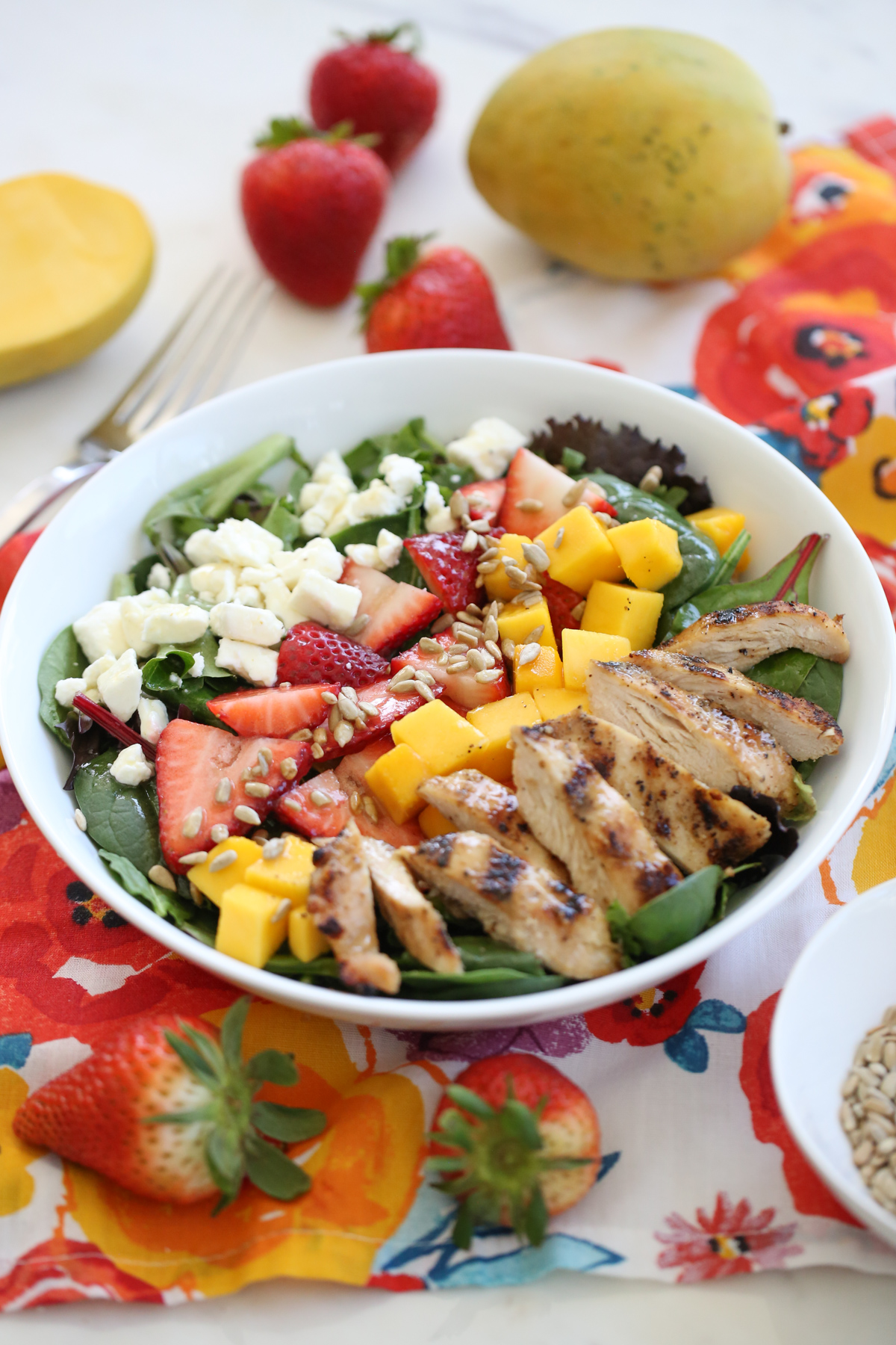 Strawberry Mango Salad in a white bowl on a colorful napkin