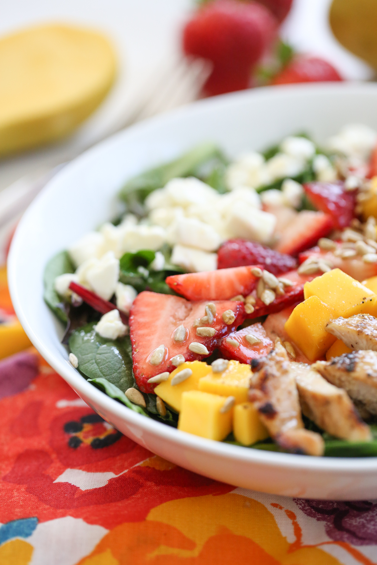 Strawberry Mango Salad in a white bowl on a colorful napkin