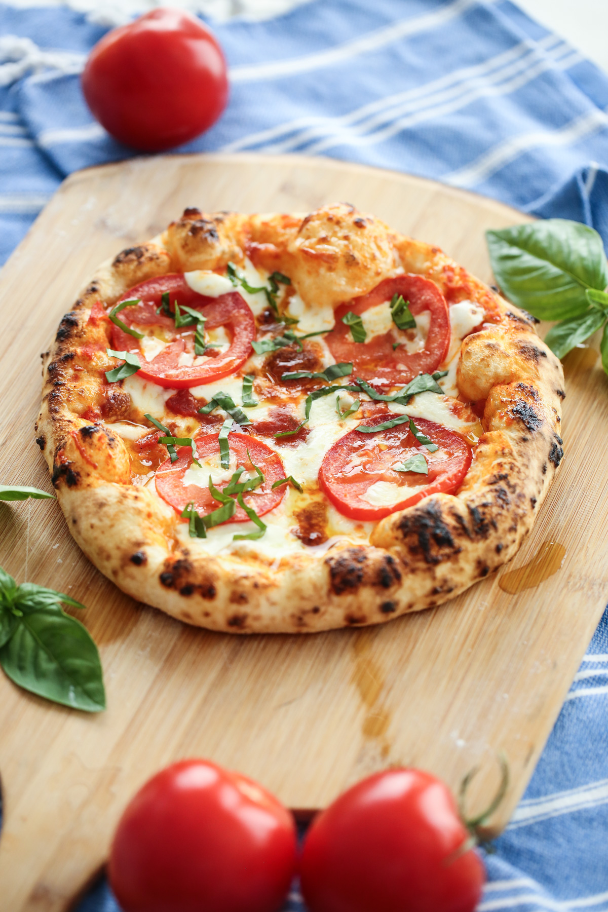 baked pizza on a peel with tomato and basil