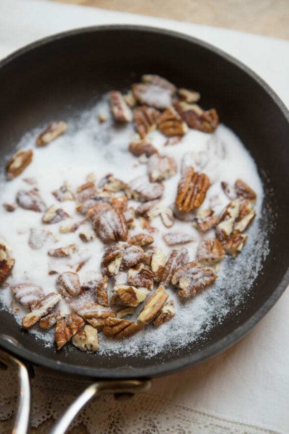 Walnuts and granulated sugar in a skillet. 