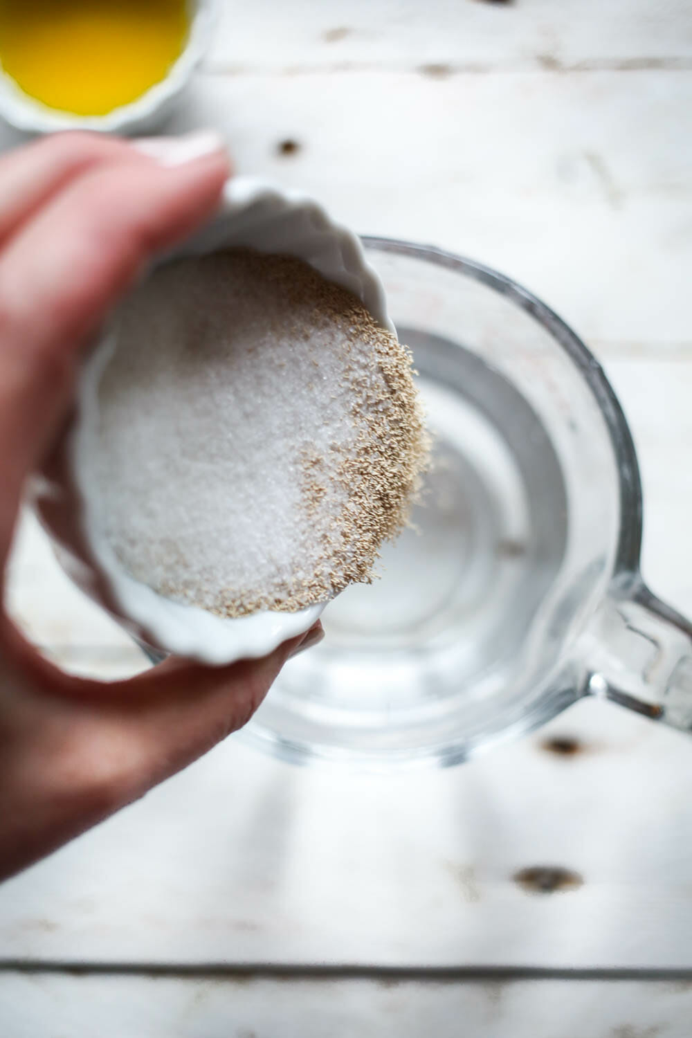 adding sugar and yeast to water