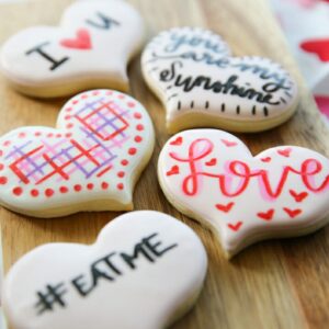 Cute valentine's cookies with white royal icing and colored marker decorations.