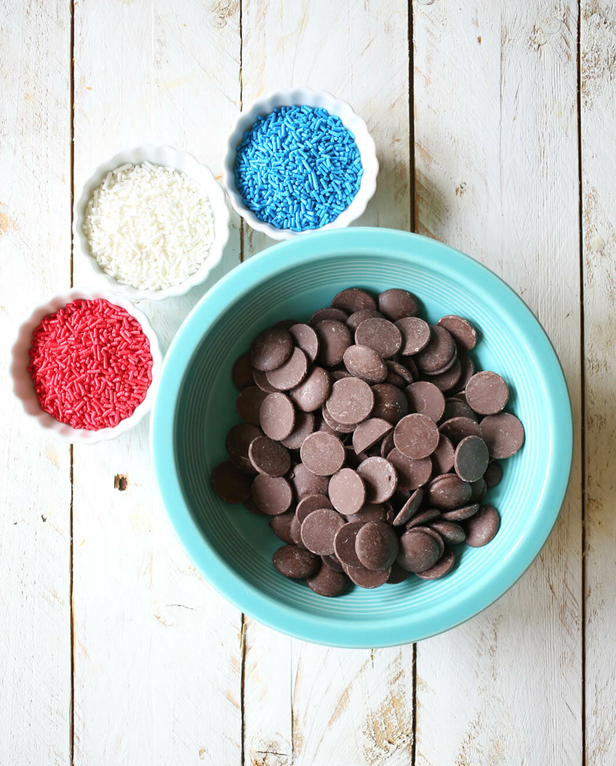 red white and blue sprinkles next to chocolate wafters, in a bowl.