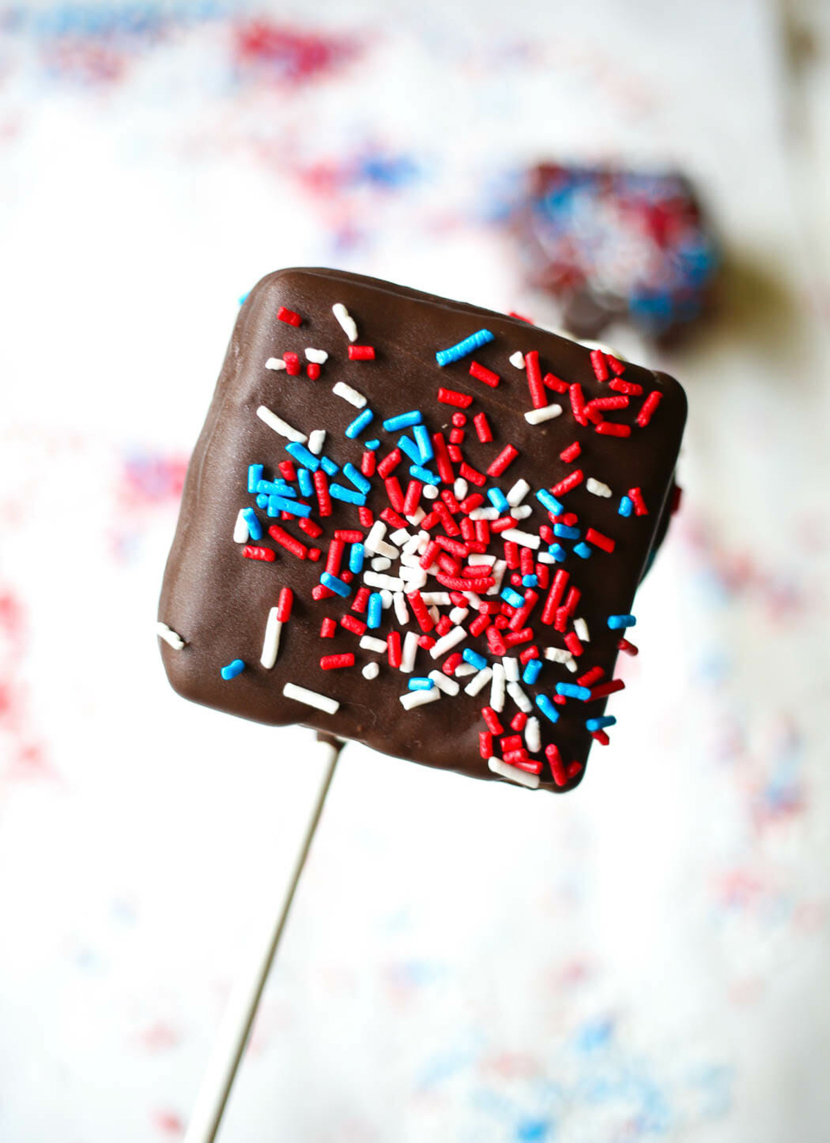chocolate covered ice cream sandwiches on sticks with sprinkles