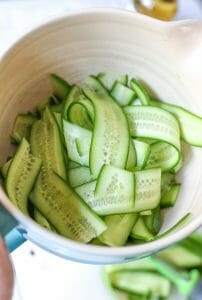 cucumber ribbons in mixing bowl for quick pickles from Our Best Bites