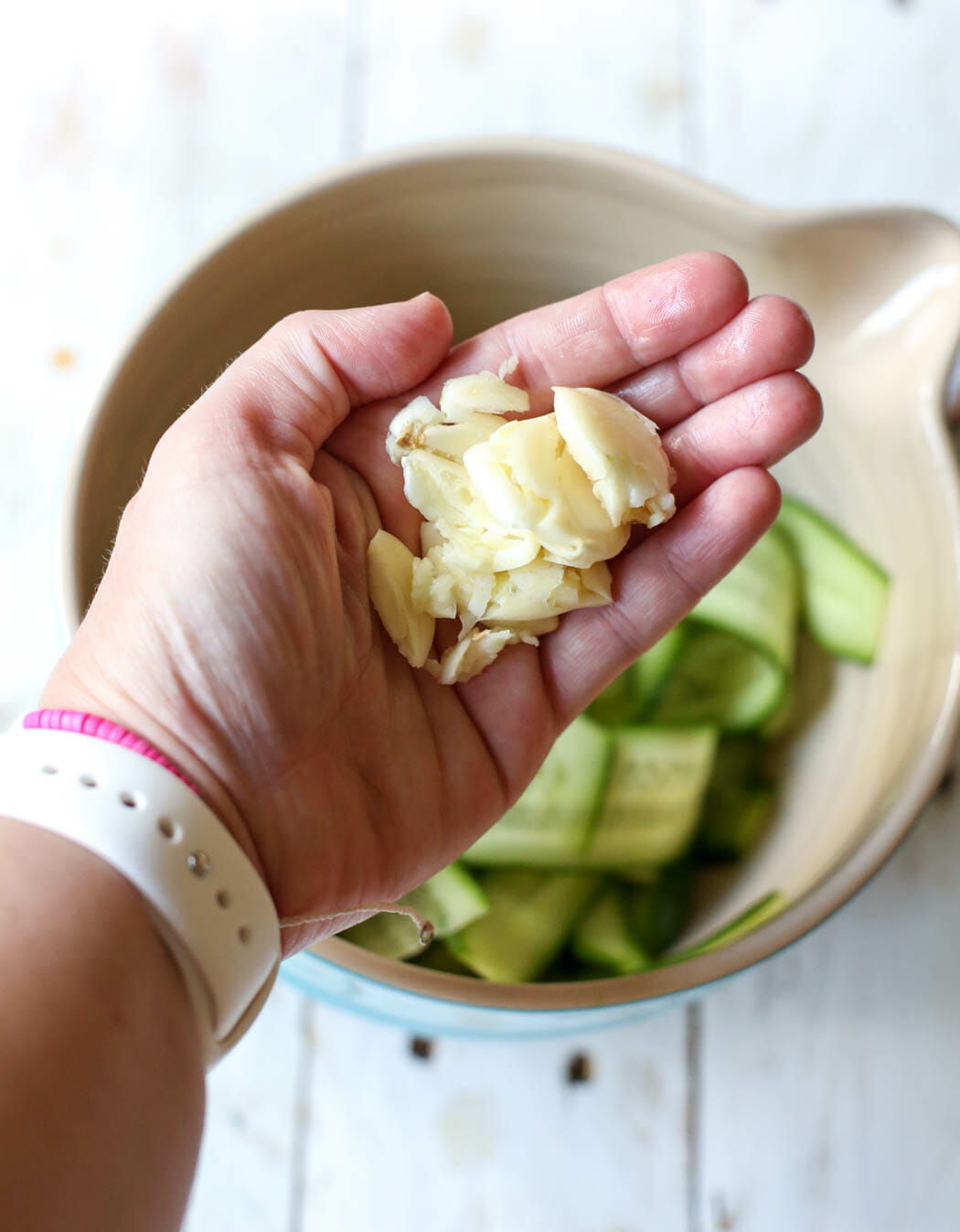 Adding garlic to cucumber ribbons for quick pickles from Our Best Bites