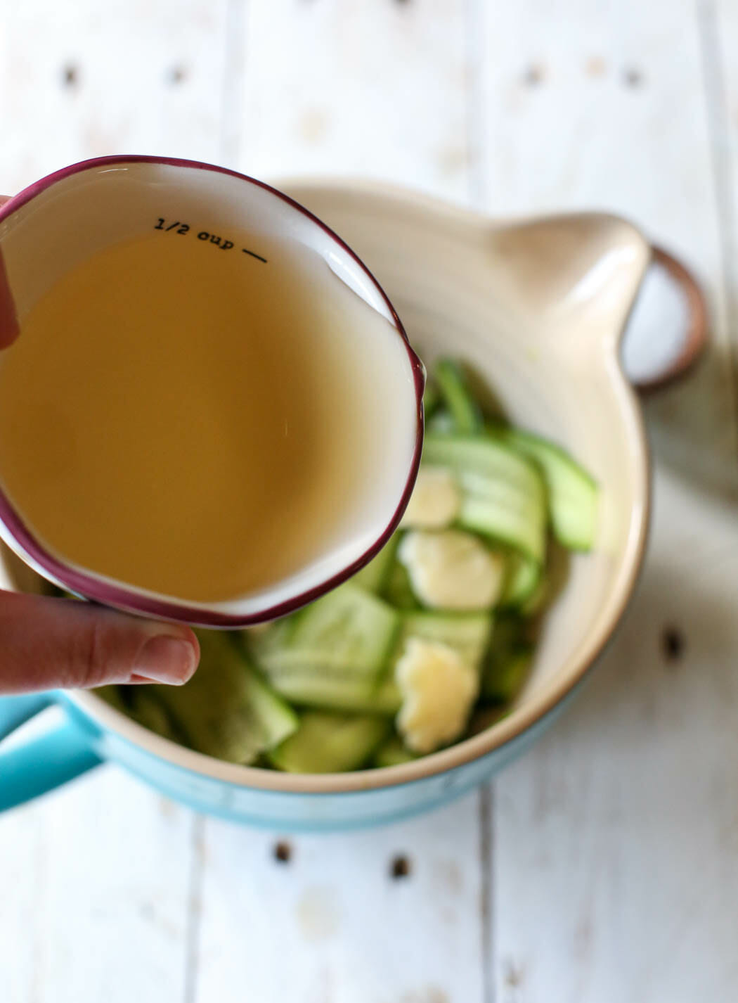 adding vinegar to cucumber ribbons for quick pickles from Our Best Bites