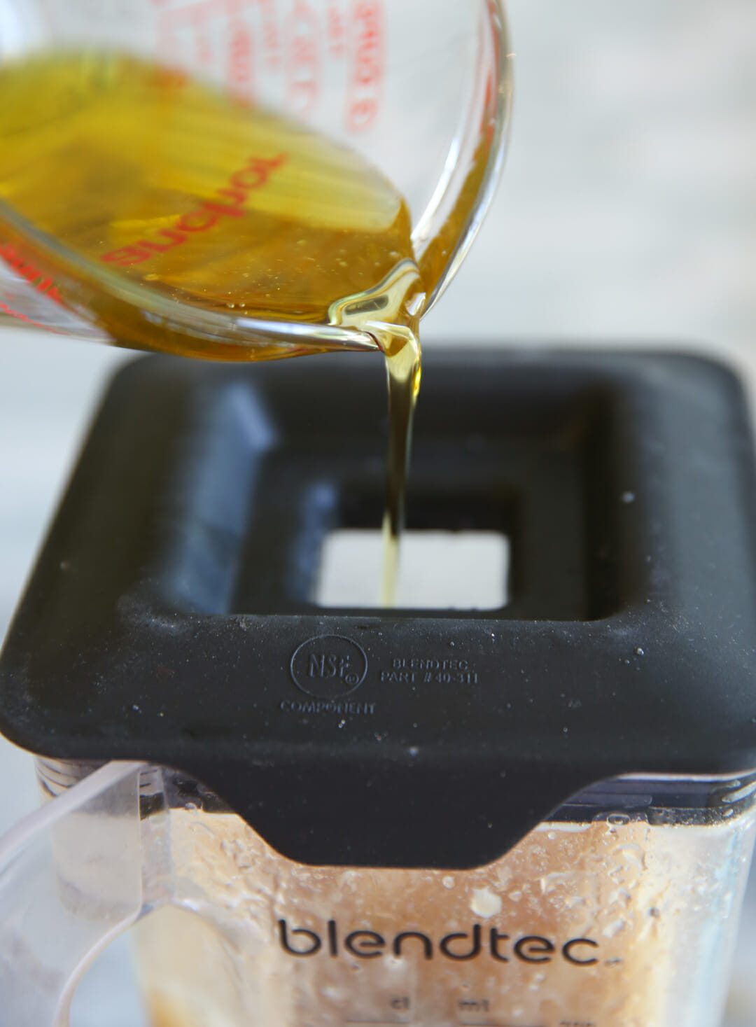 adding oil to blender