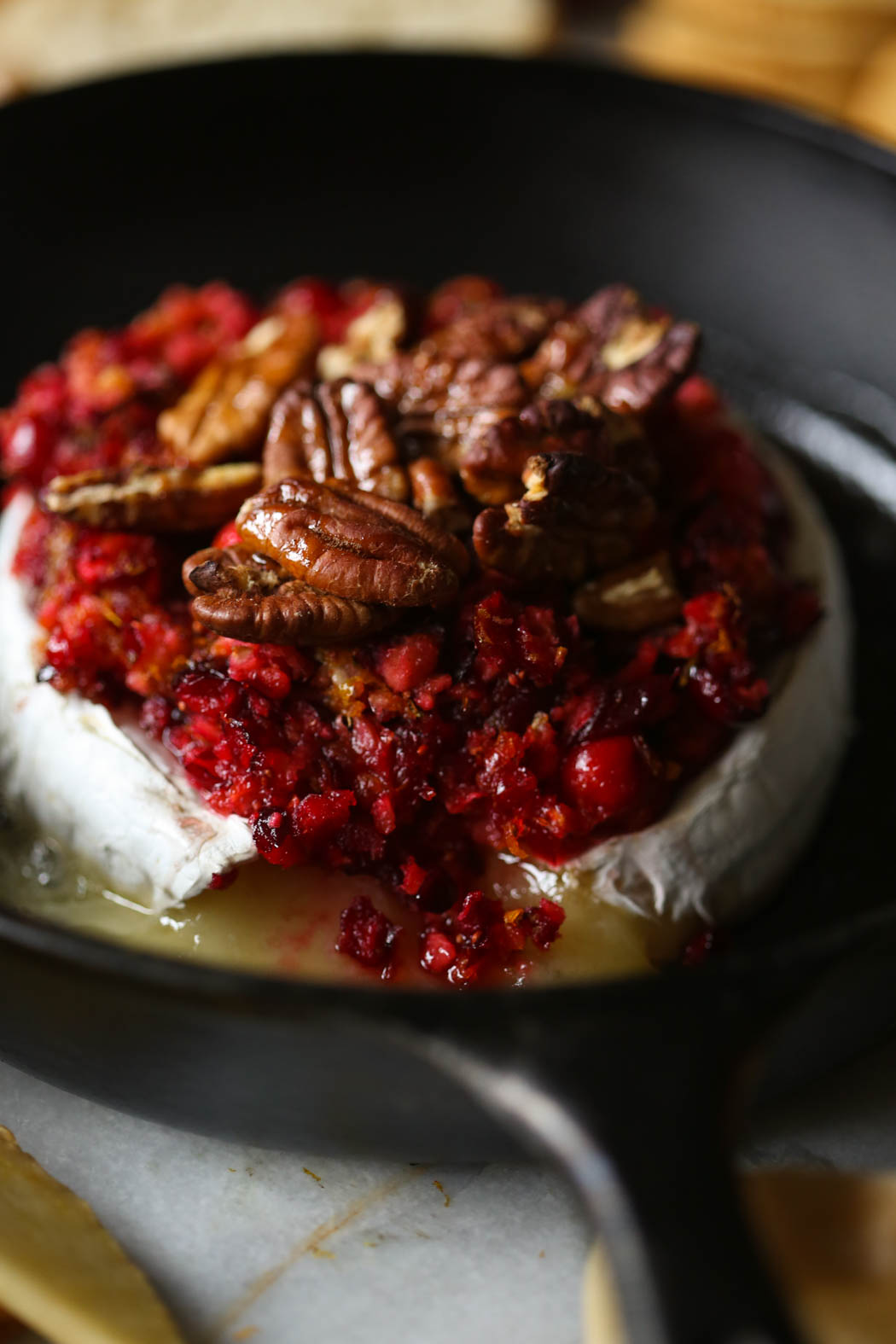 cutting into orange cranberry baked brie from Our Best Bites