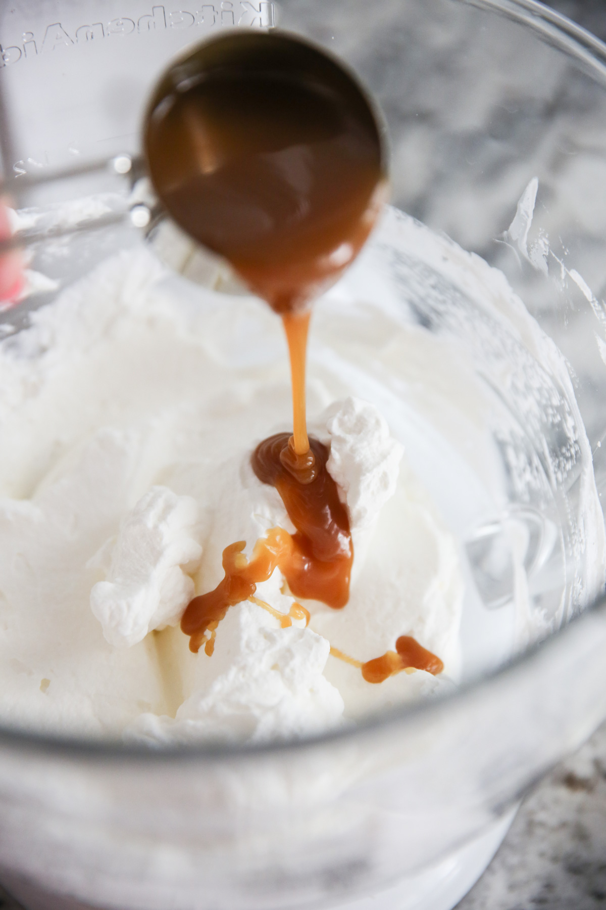 pouring caramel on whipped cream