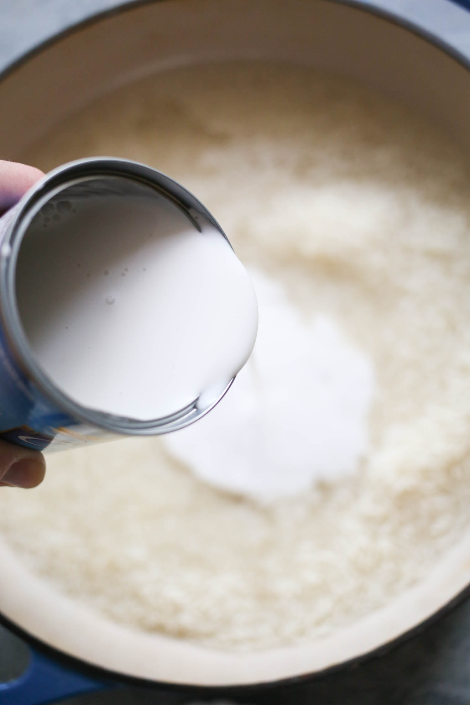 adding coconut milk to sweet and savory coconut rice from our best bites
