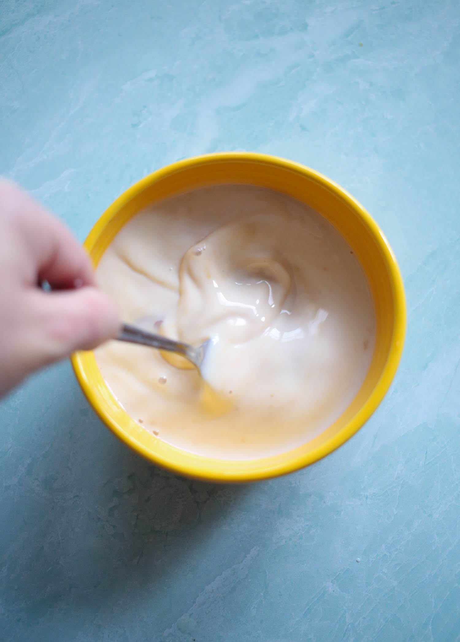 whisking milk, eggs, and vanilla for mixed berry baked oatmeal from our best bites