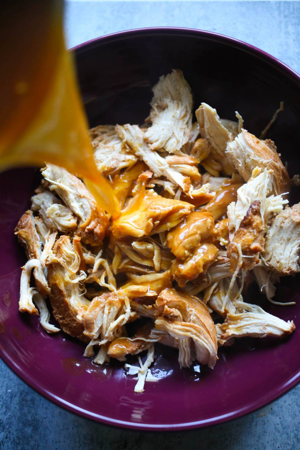adding sauce to slow cooker honey garlic chicken