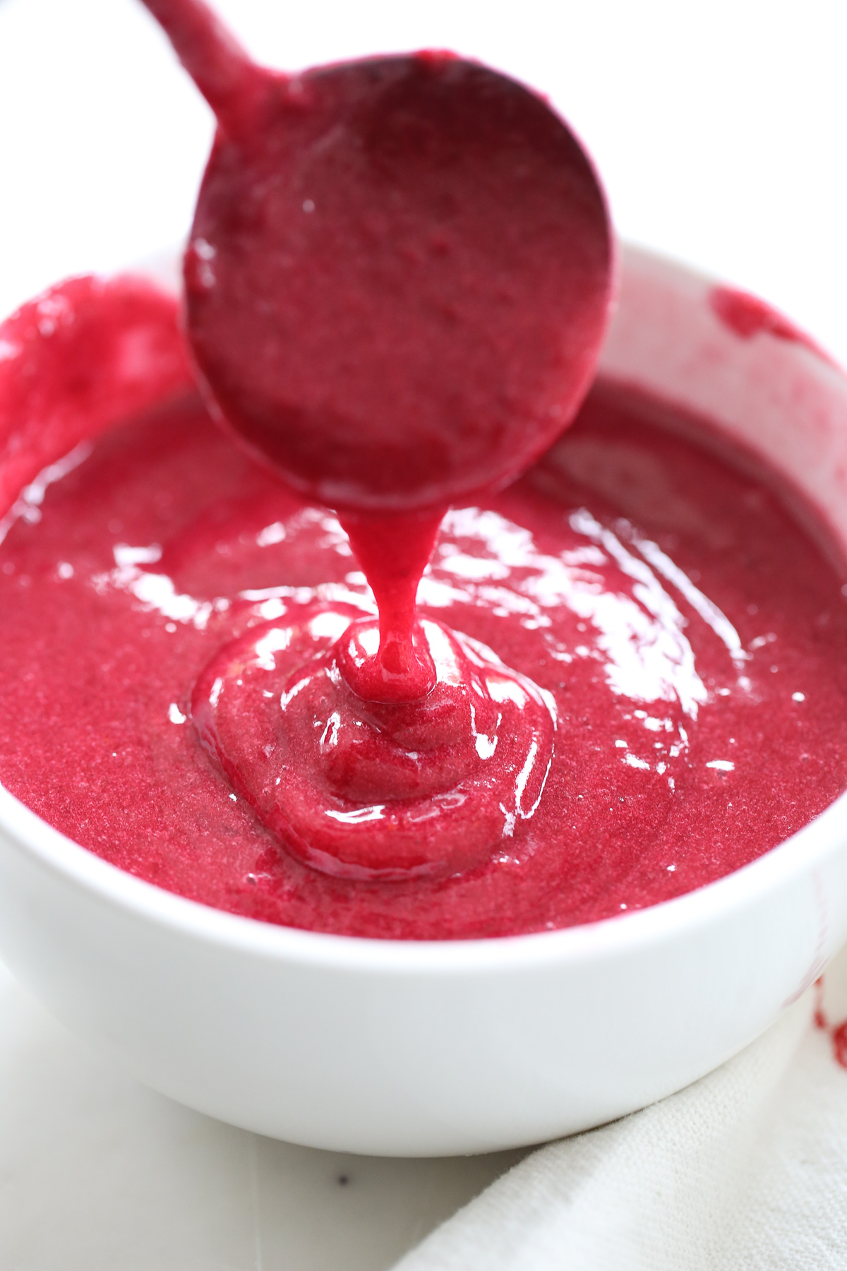 fresh cranberry sauce being drizzled in a bowl