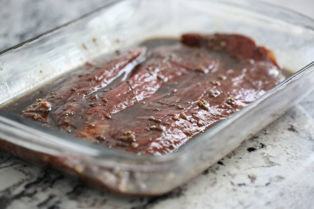 Flank steak marinating in a 9x13 pan