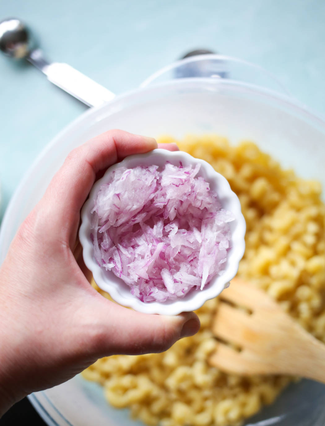 adding onions to macaroni salad