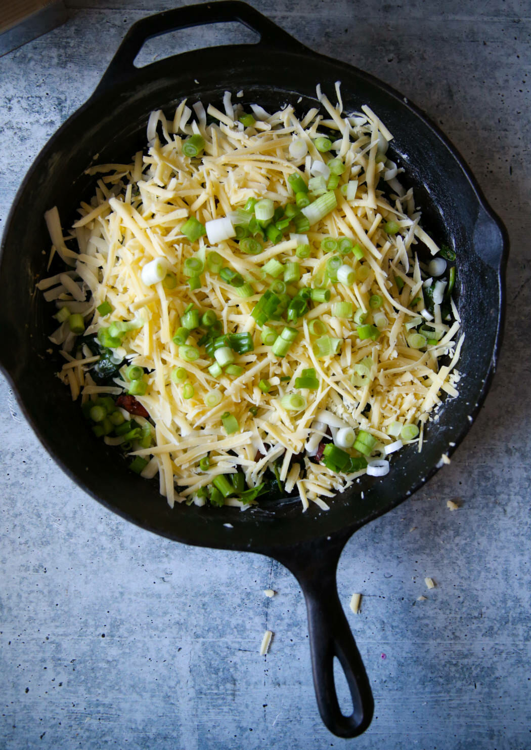 cheese and green onions over bacon and spinach