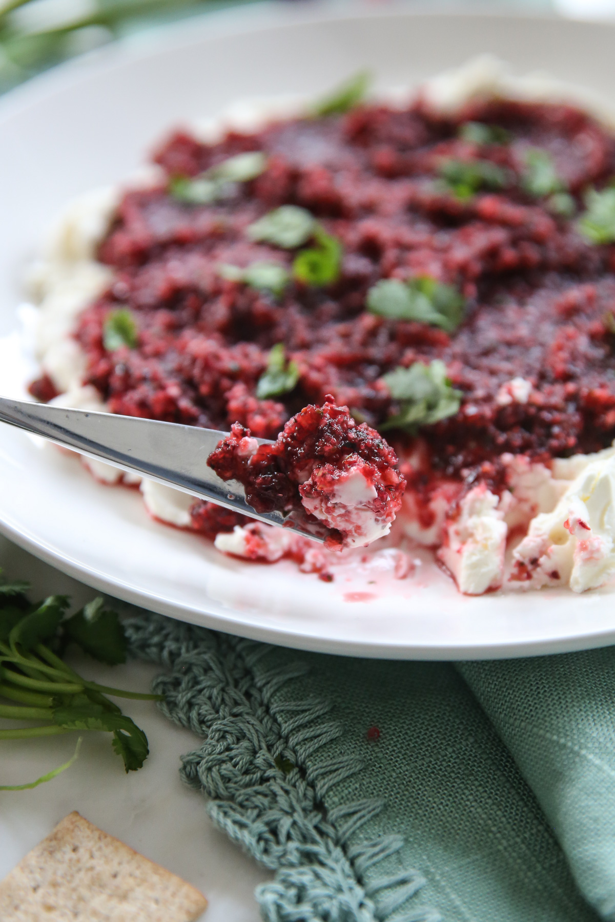 scooping cranberry salsa onto cracker