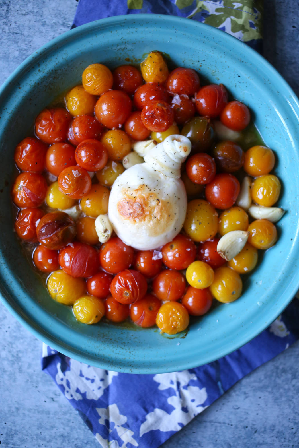 roasted burrata with tomatoes and garlic in a pie plate