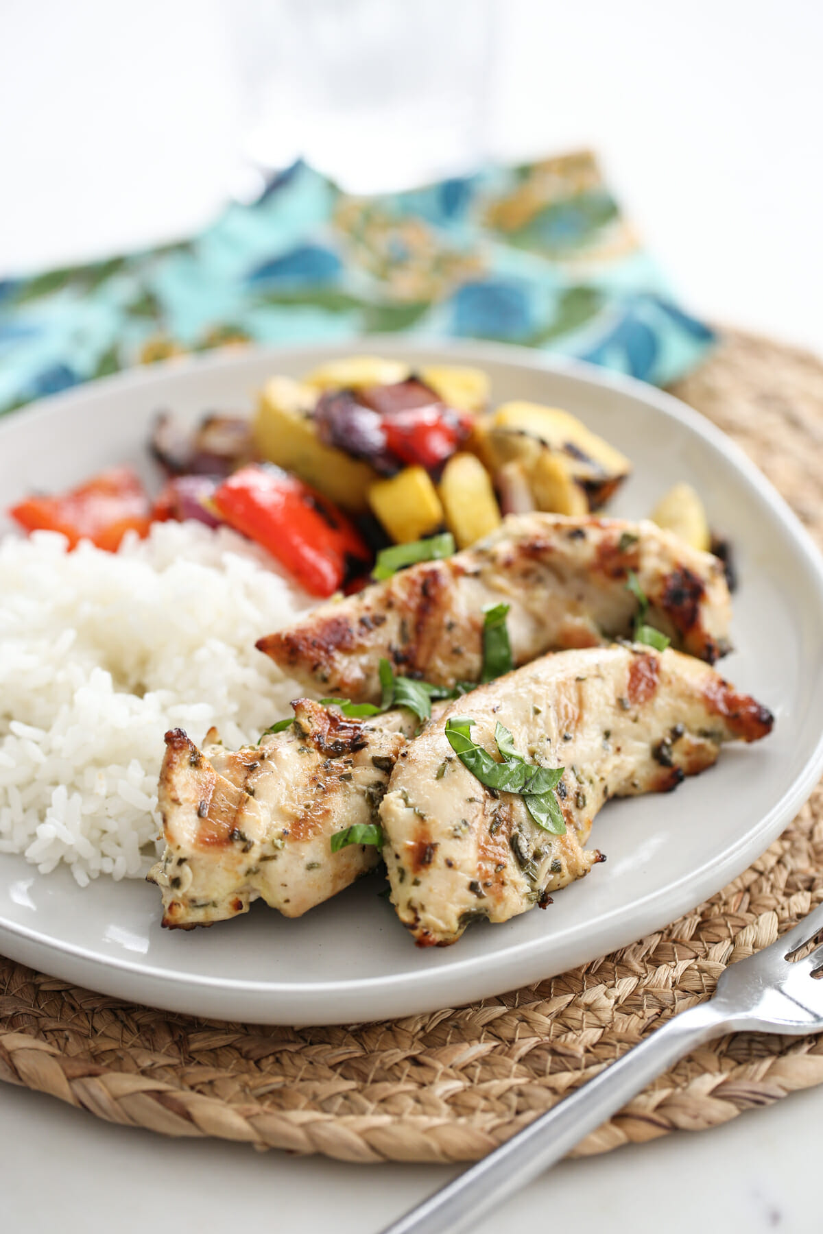 Lemon Garlic Herb Rubbed Chicken on a plate with white rice and roasted veggieswhite platter with lemon slices