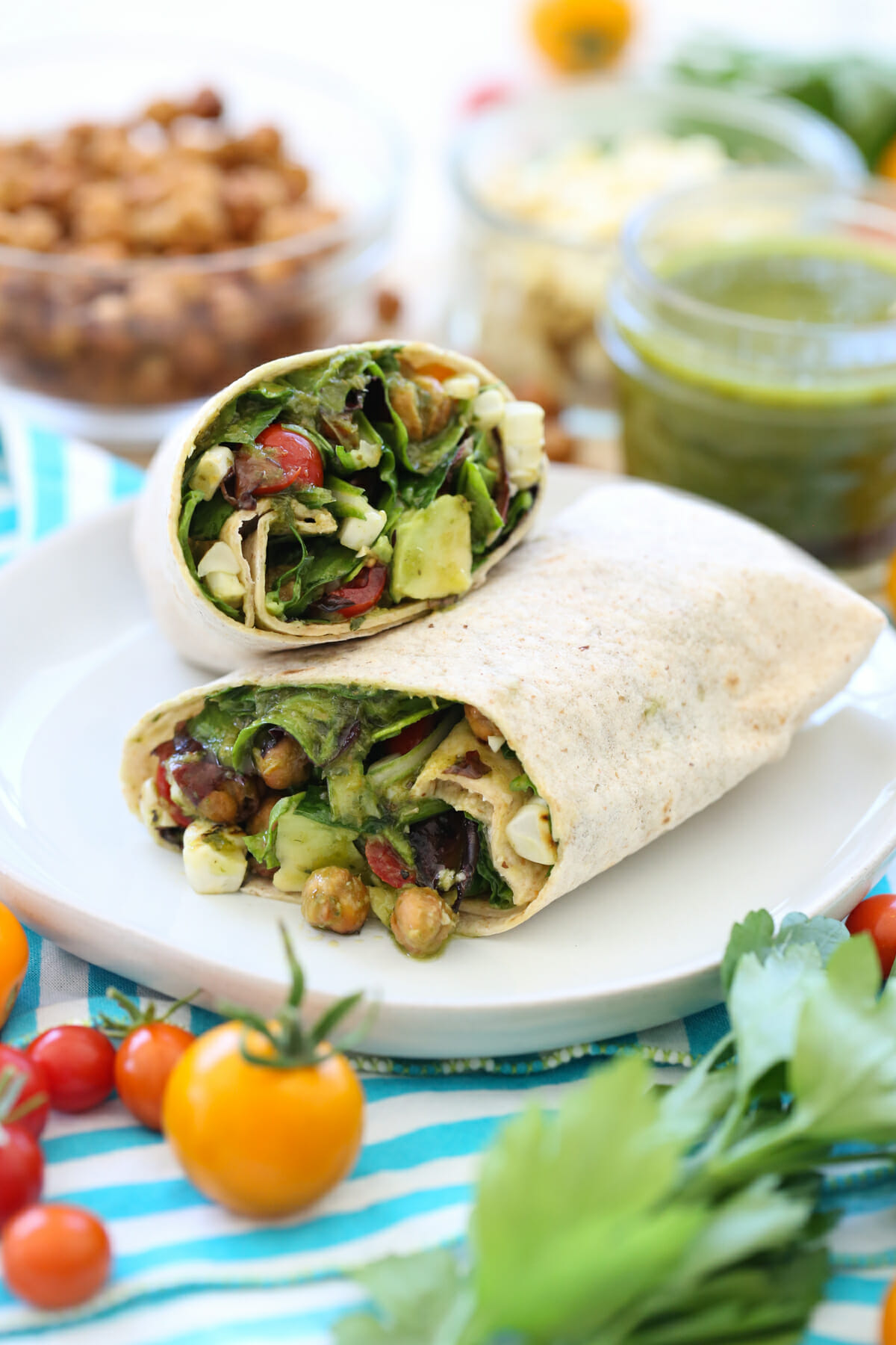 A veggie wrap, cut in half, on a white plate. 