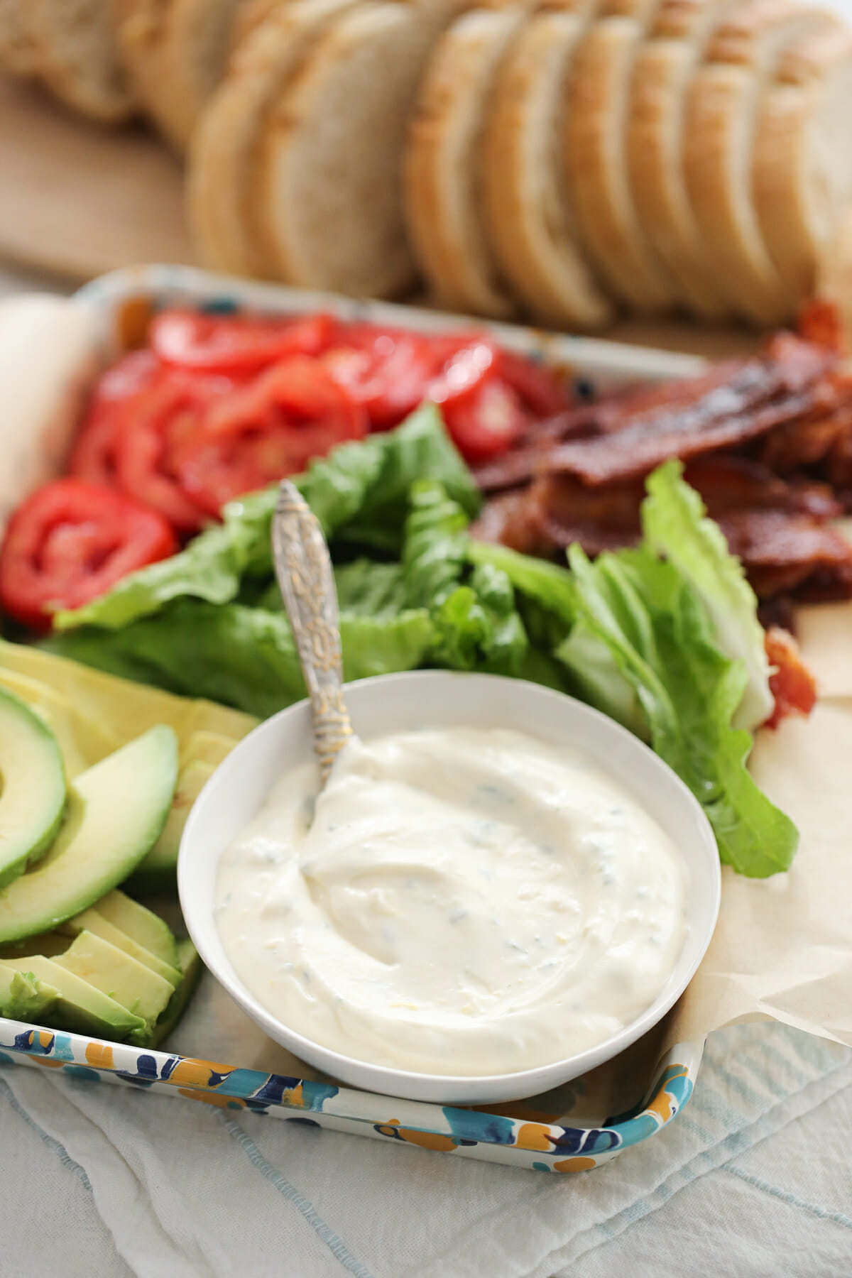 Garlic-Herb Sandwich Spread in a bowl, surrounded by other condiments.