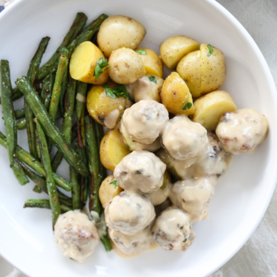 Swedish Meatballs on a plate with potatoes and green beans.
