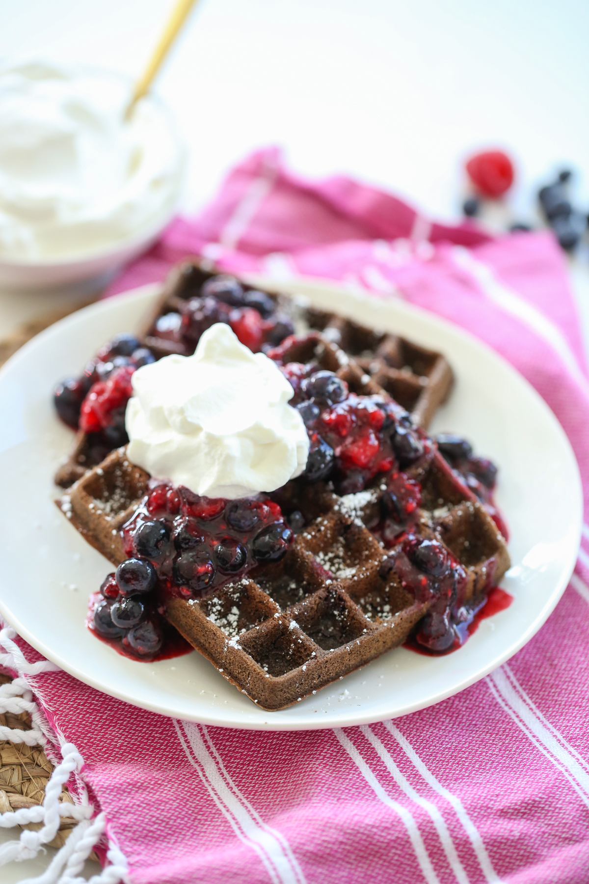 Chocolate Waffles with whipped cream and berries on a plate