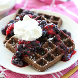 Chocolate Waffles with whipped cream and berries on a plate