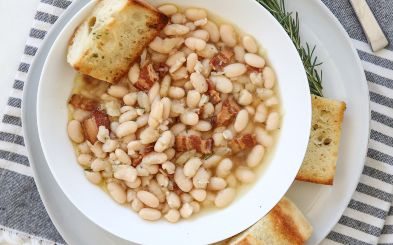 bowl of white beans with garlic bread on the side