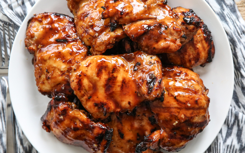 Huli Huli grilled chicken thighs on a white plate.