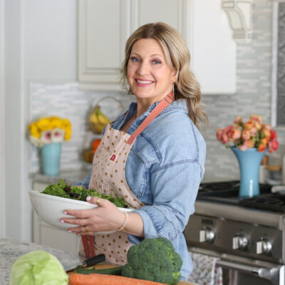woman in denim shirt holding a salad bowl