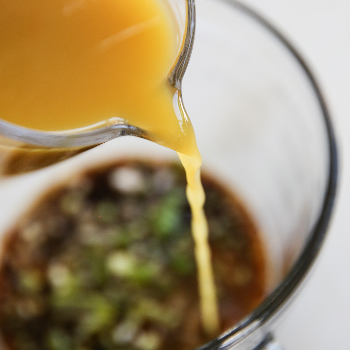pouring pineapple juice into marinade