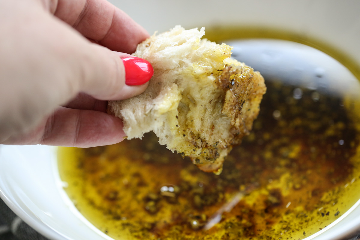 Dipping a chunk of bread into dipping oil