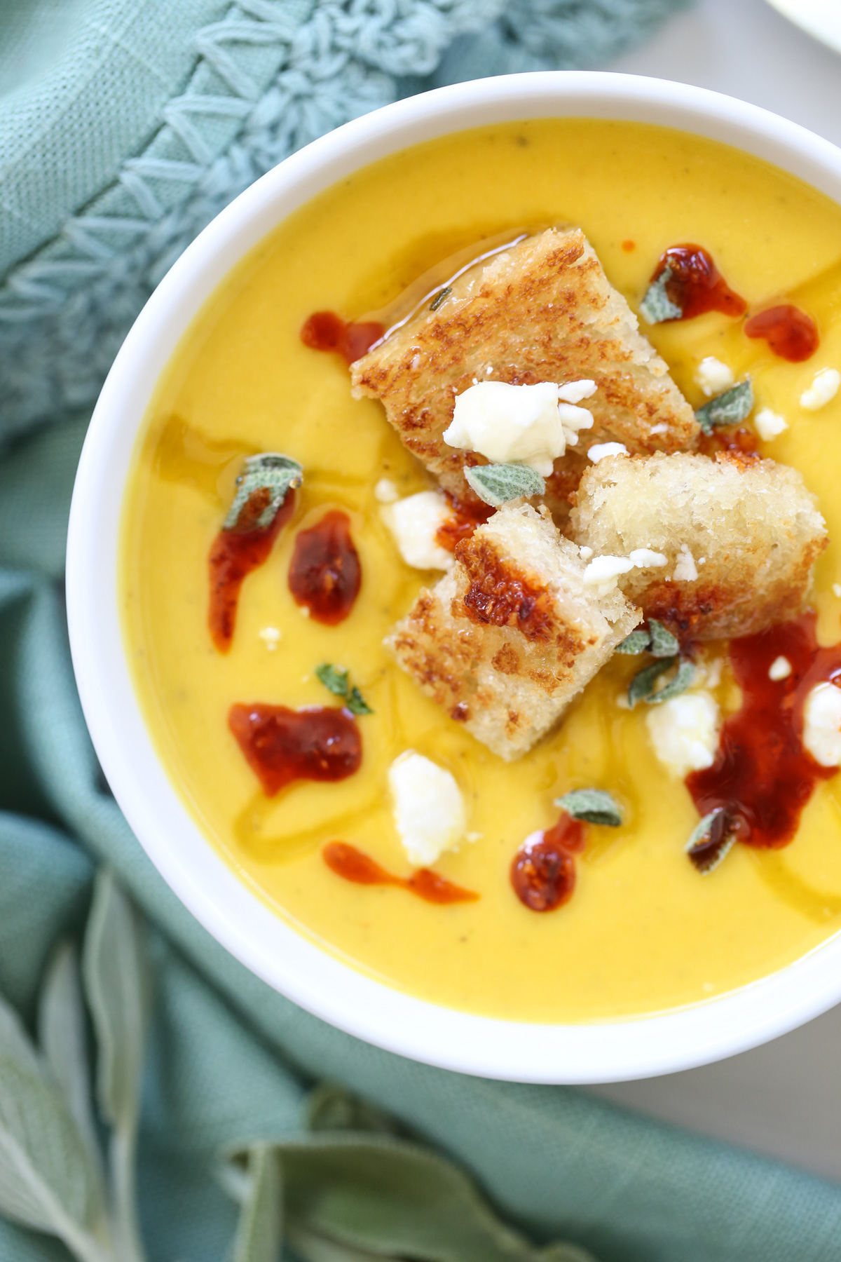 Roasted butternut squash soup with feta in a white bowl