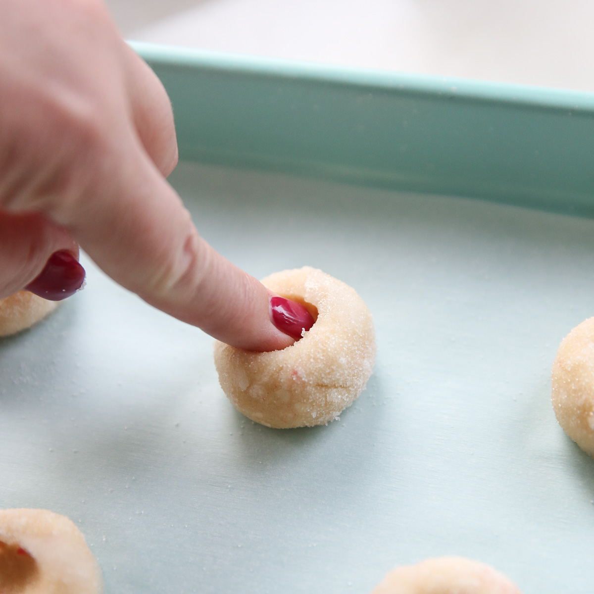 pressing indentation in a ball of cookie dough