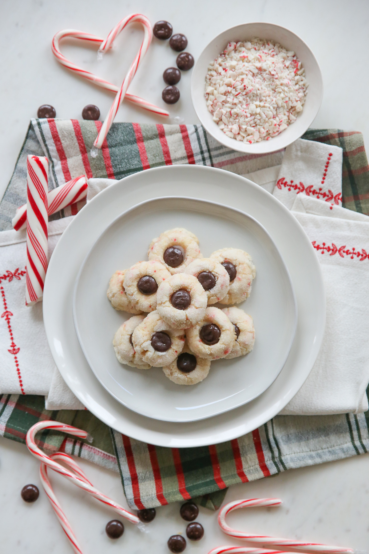 serving plate with candy cane cookies surrounded by holiday baking ingredients