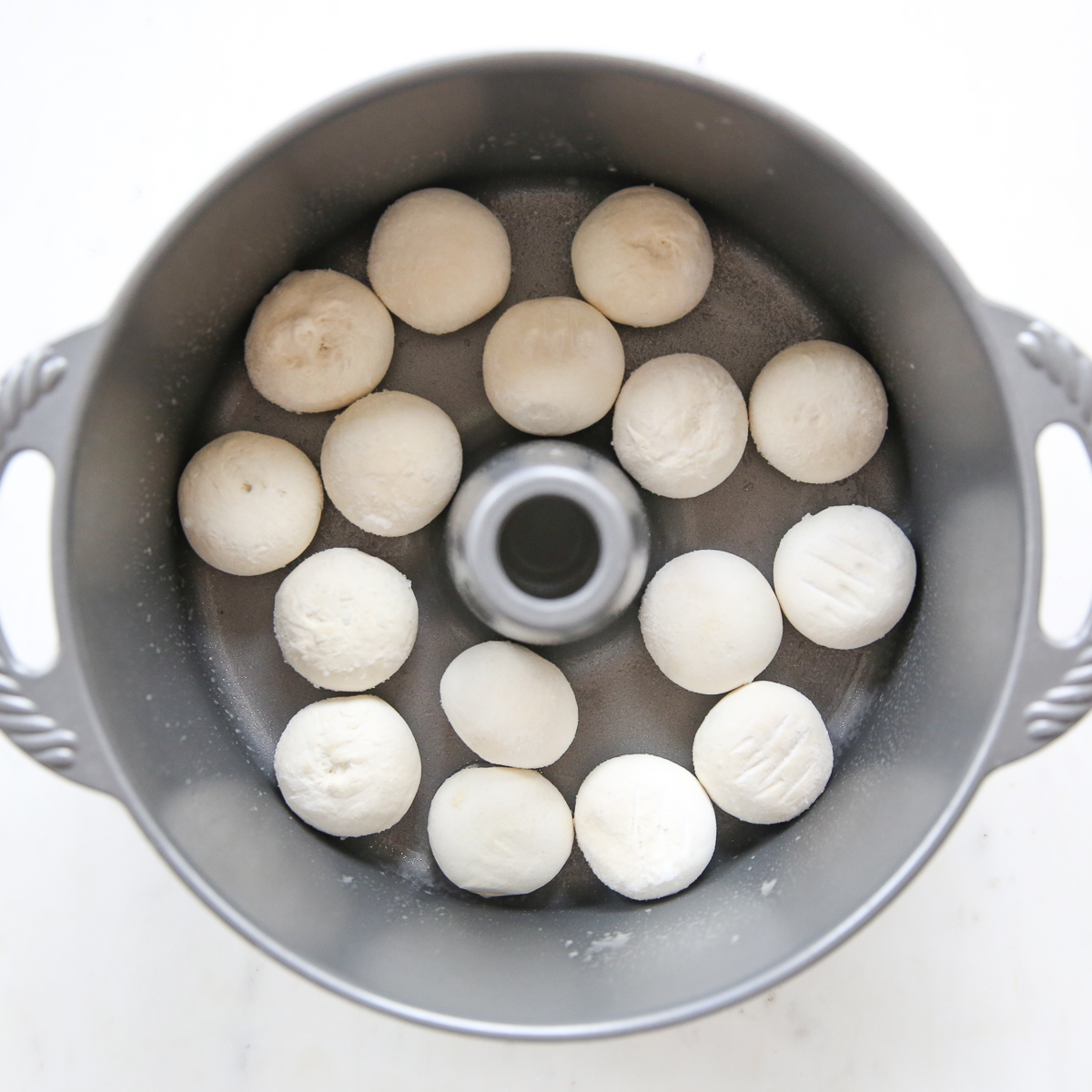 assembling overnight caramel rolls in a bundt pan