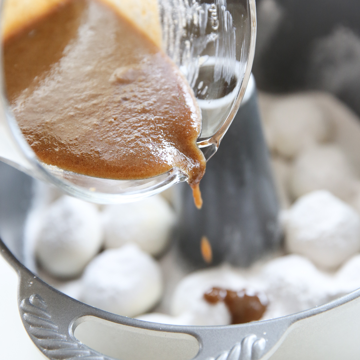 pouring caramel syrup over sticky buns