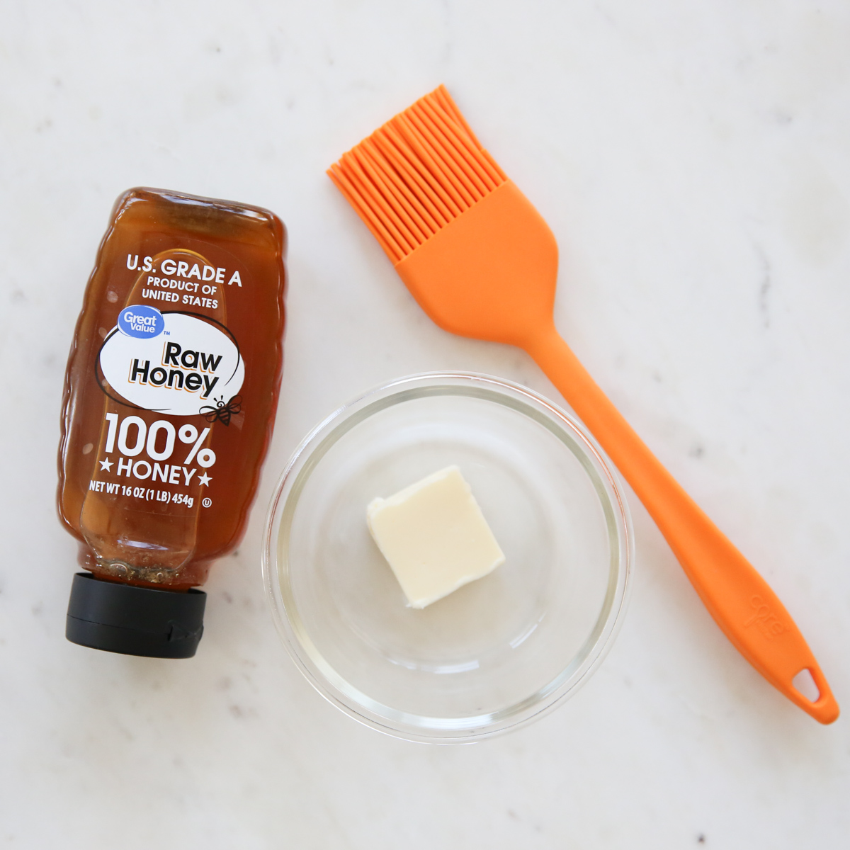 honey, butter, and a silicone brush on a table top